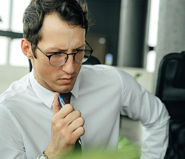Man thinking with pen in hand