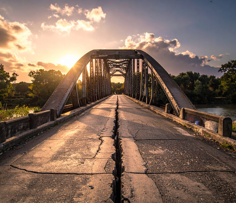 Cracking road under bridge