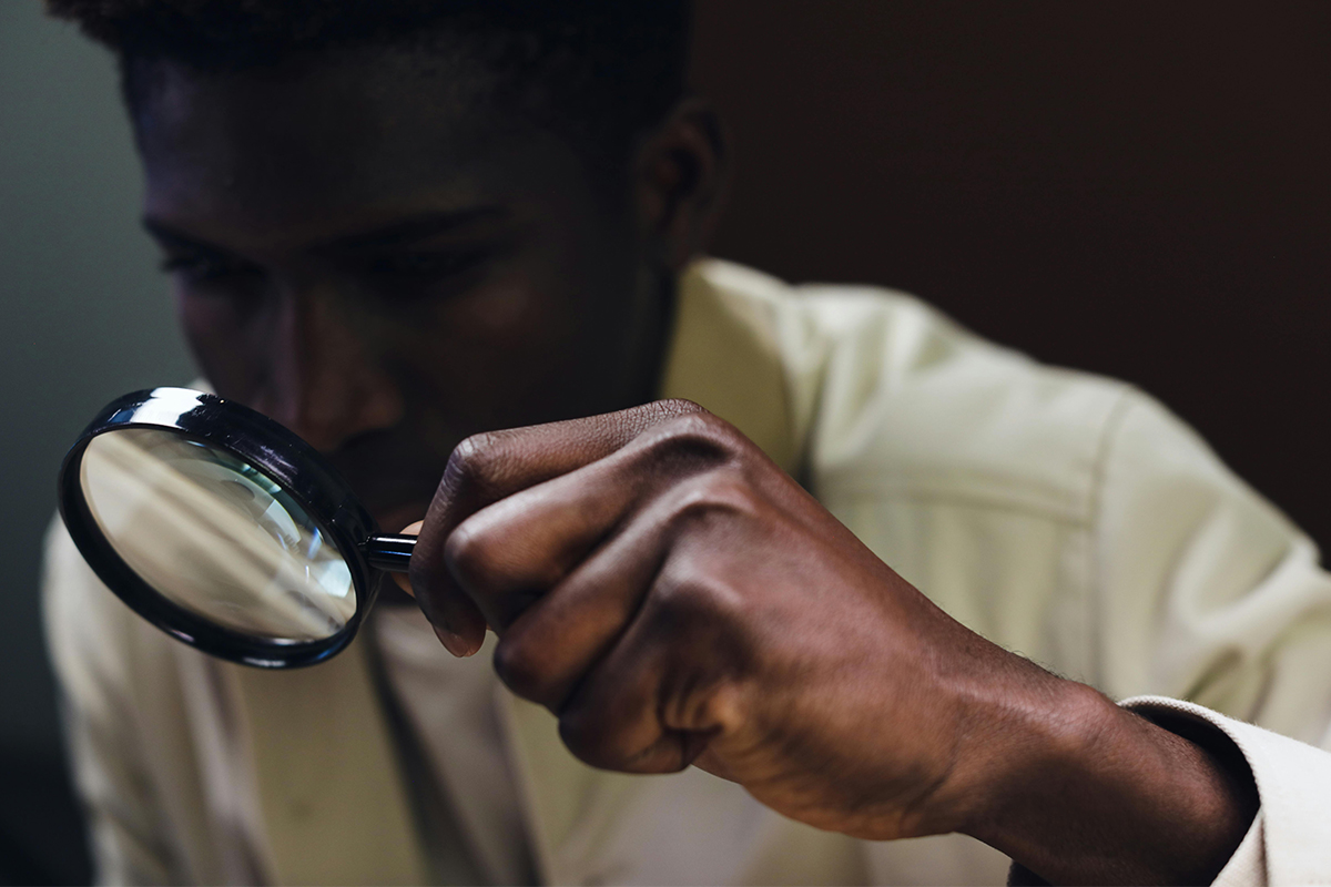 Man holding magnifying glass to his eye